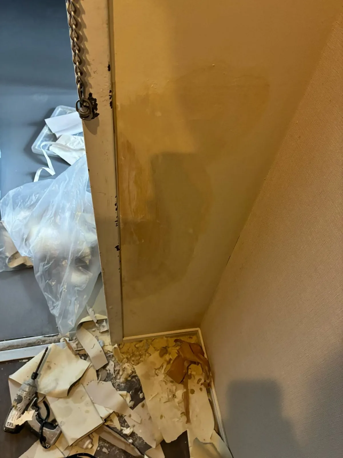 壁紙で覆われていない面が広く見える出入口脇の状態